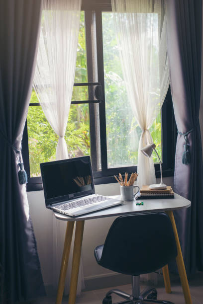 istock Desk for student education concept. Desktop Laptop, Pencils, book, note pad, lamp, and pins placed on School table for student work online at home. 1408271921