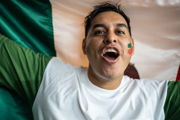 istock Fan man celebrating winning holding Mexican flag 1408273512