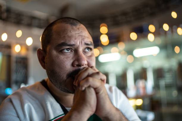 mid adult man watching a soccer game at bar - fan television football watching tv imagens e fotografias de stock