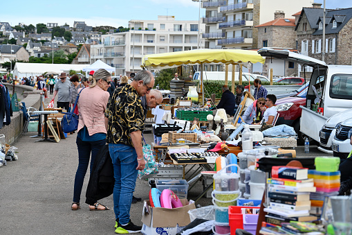 Erquy, Britany, France, June 26, 2022 - People on outdoor flea market on the boulevard de la mer in Erquy