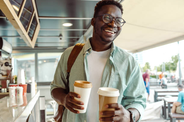 afroamerikanischer student, der einen kaffee holt - black hole stock-fotos und bilder