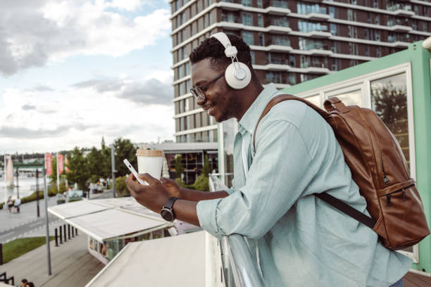 istock Young African-American man consuming internet content outdoors 1408278773