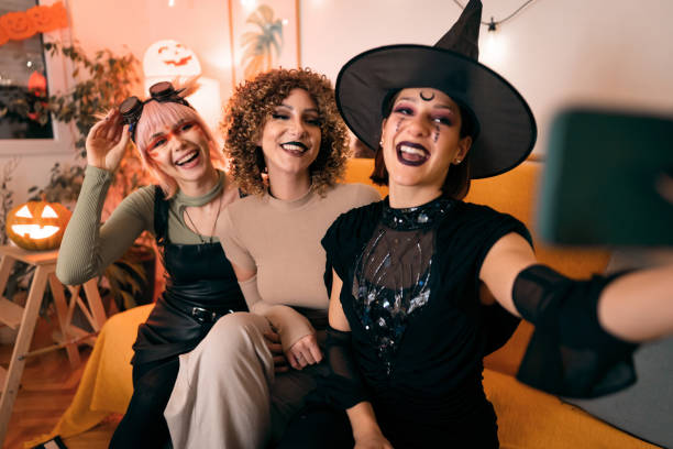 Three young women taking selfies at Halloween party stock photo