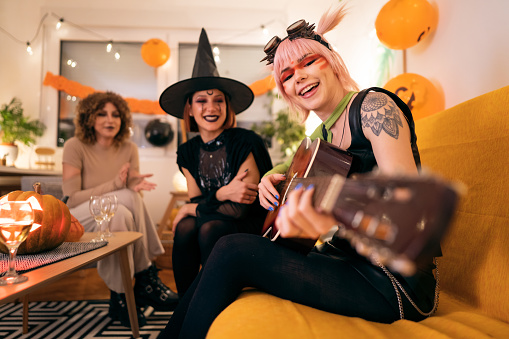 Three young women in costumes having fun at the Halloween party.