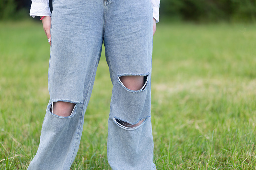 Jeans are full of holes.Specially cut. Fashionable jeans.