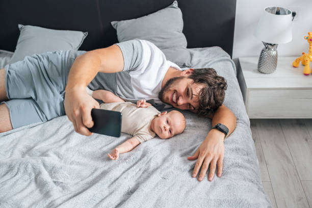 istock Father taking a selfie with his baby son using smartphone. 1408281700