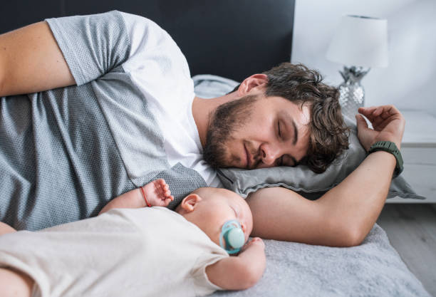 istock Young father sleeping beside baby son. 1408281786