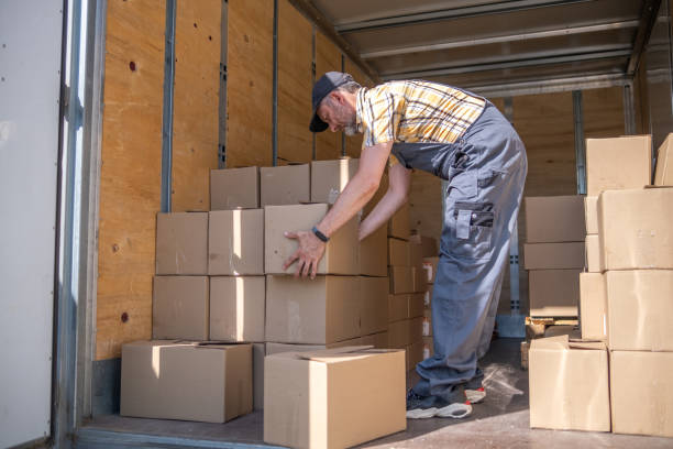istock A cheerful worker unloads cartons of goods 1408282641