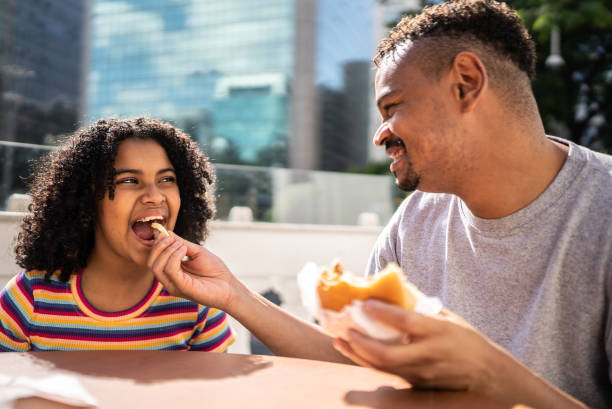 Father giving french fries to daughter