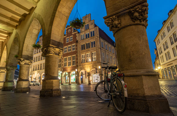 Bicycle City Münster - Bicycle at the Prinzipalmarkt Blue hour at the Prinzipalmarkt in the old town of Münster with bicycle in the arcade munster stock pictures, royalty-free photos & images
