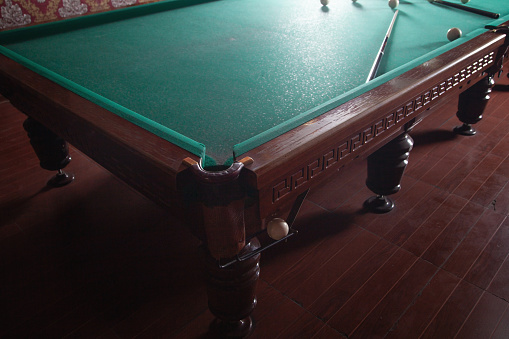 A Half shot of a old Carrom standing straight with the table