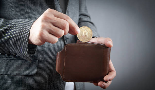 istock Man putting Bitcoin to his wallet. 1408285815