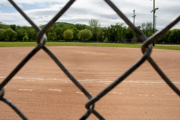 istock seeing a baseball diamond through the classic diamond-shaped fence with tan clay 1408289261