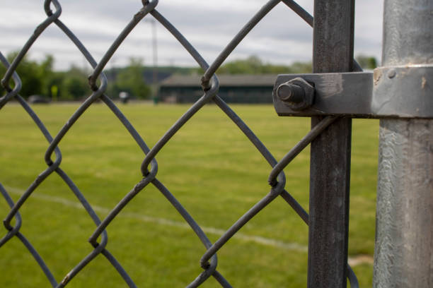 istock seeing a baseball green grass diamond field through the classic diamond-shaped fence 1408289270