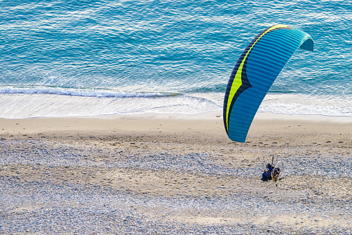Paraglider flying over beach sea shore. Paragliding. Extreme sport.