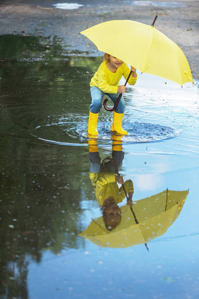 istock children walk through the puddles after the rain 1408291893