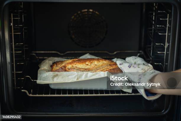 Woman Wearing Potholder Taking Fresh Banana Bread Out Of The Oven Close Up Of Hot Homemade Pastry Stock Photo - Download Image Now