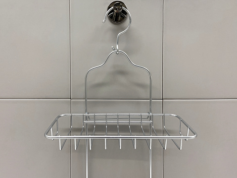 Metallic soap dish hanging on the tile wall, front view metal soap dish hanging on the kitchen or bathroom wall