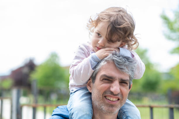 istock Father walking with his princess on sitting his shoulders. 1408301016