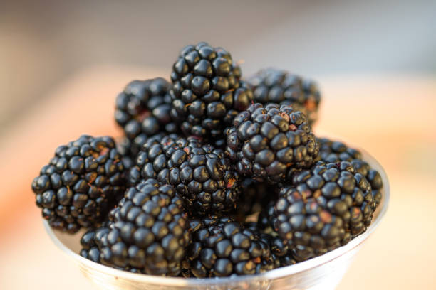 istock Fresh sweet blackberry in glass on a wooden table, rustic background, selective focus 1408301313
