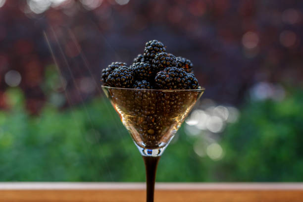 Fresh sweet blackberry in glass on a wooden table, rustic background, selective focus