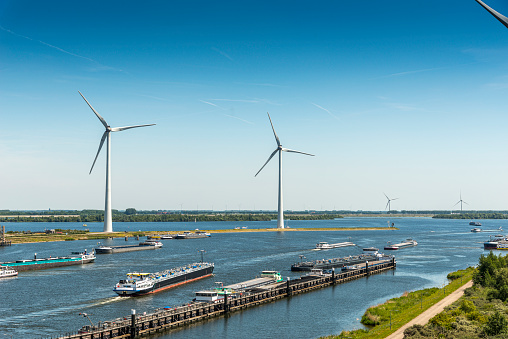 Ship lock South of Rotterdam close to Numansdorp. Summer day with wind turbines in the background, river barges leaving the lock