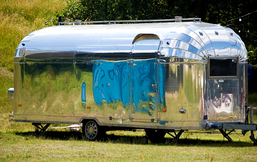 Poznan, Poland, July 3th 2022: Classic Airstream trailer parked in a meadow.