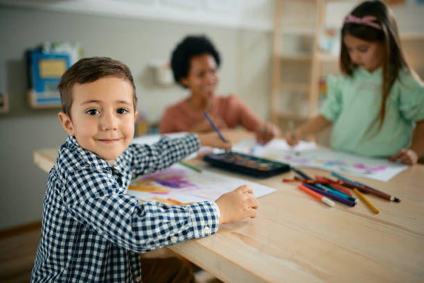 istock Happy kid enjoying on art class at preschool and looking at camera. 1408303838