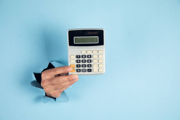 istock A man hand holds a calculator on blue background 1408306053