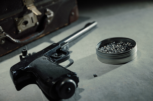 bullets and gun on black velvet desk