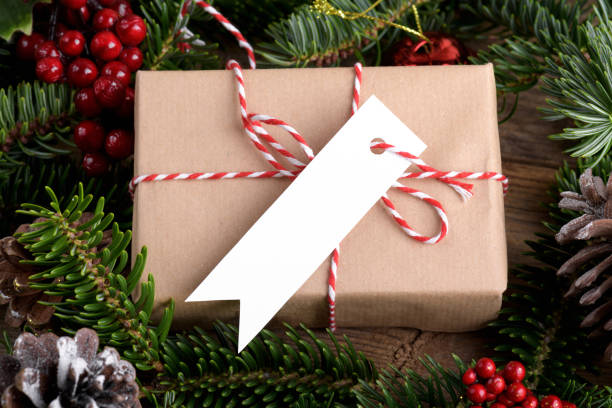istock Christmas rectangle strip gift tag mockup with present box, product label mockup, with natural fir tree branch, name tag 1408308905