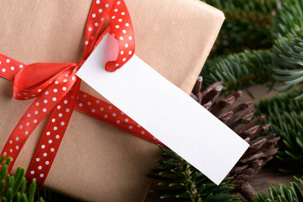 istock Christmas rectangle strip gift tag mockup with present box, product label mockup, with natural fir tree branch, name tag 1408308916