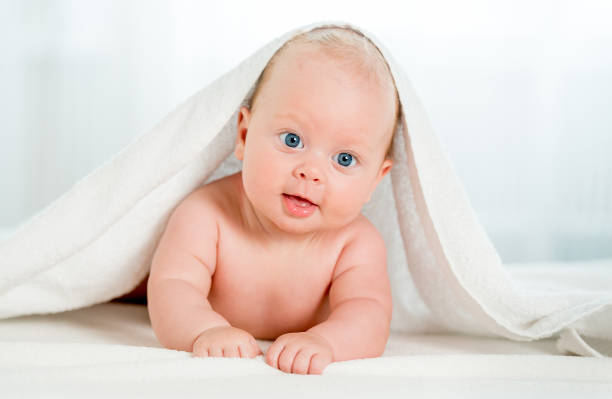 istock Newborn baby under the white towel 1408310136