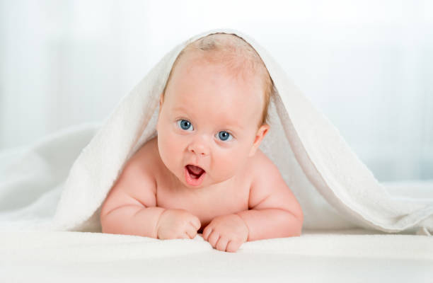 istock Newborn baby under the white towel 1408310137