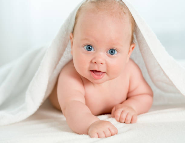 istock Newborn baby under the white towel 1408310139