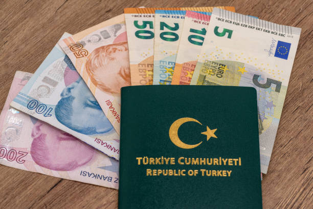 Euro (EUR), TL banknotes lined up on wooden table and Turkey green passport on it Euro (EUR), TL banknotes lined up on wooden table and Turkey green passport on it para birimi stock pictures, royalty-free photos & images