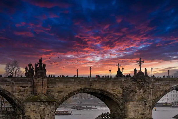 The Charles bridge in Prague, Czech republic photo with dramatic sky background in the late afternoon.