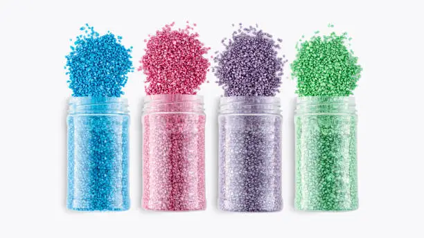 A set of cans with multicolored glitter crystal salt for aroma spa. Shimmering sea salt jars isolated on white background. Cans of bath salt. The idea of home relaxation, aromatherapy and self care.