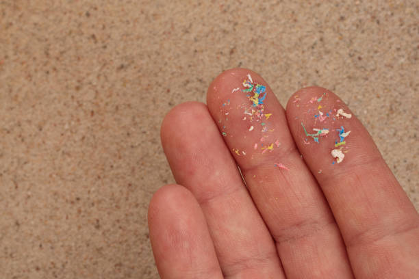 istock Micro-plastic on the palm of your hand, top view of the beach. Evironmental problem. 1408314881