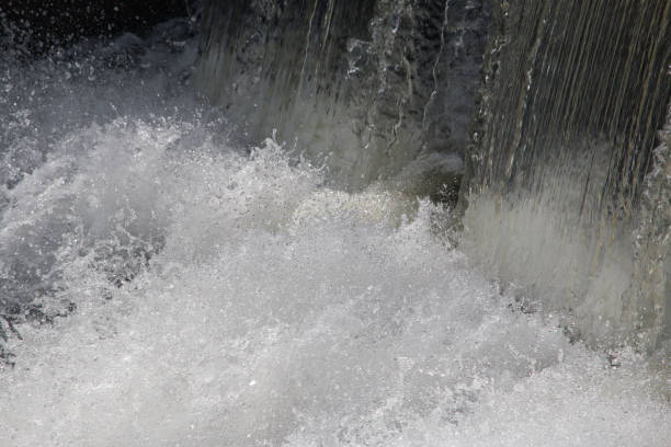 Water bubbles and froths at the bottom of a dam used for flood and water control after abundant rain