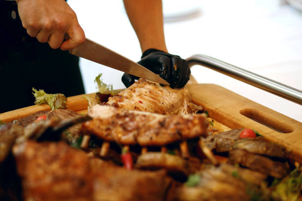 istock the cook in the restaurant cuts the meat cooked on the fire 1408316435