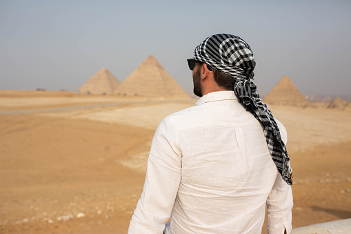 A young tourist in front of the pyramids