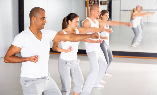 istock Group of beginners mastering martial arts for self defence in gym 1408318018
