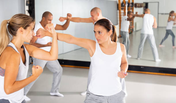 istock Hispanic woman practicing self defense moves with female partner 1408318019
