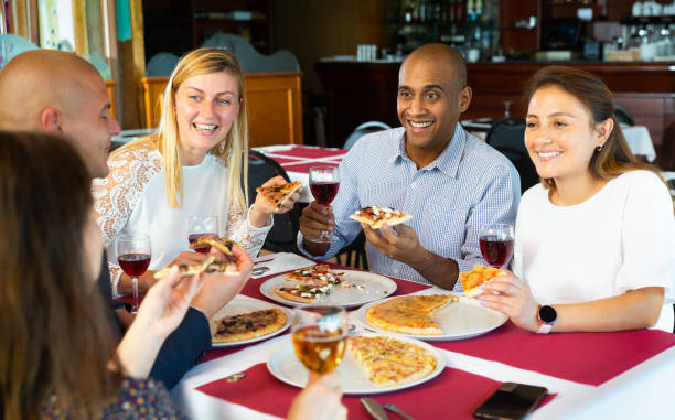 istock Positive people enjoying pizza and wine in cozy restaurant 1408318657
