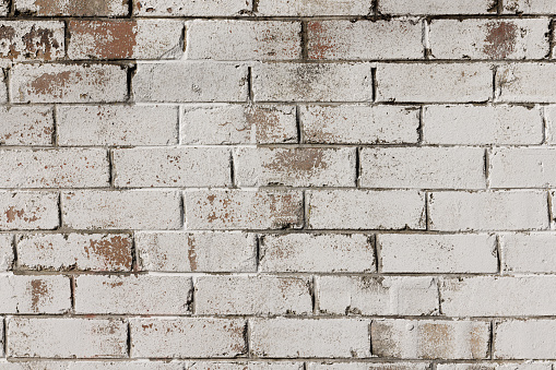 Section of an old faded white brick wall.