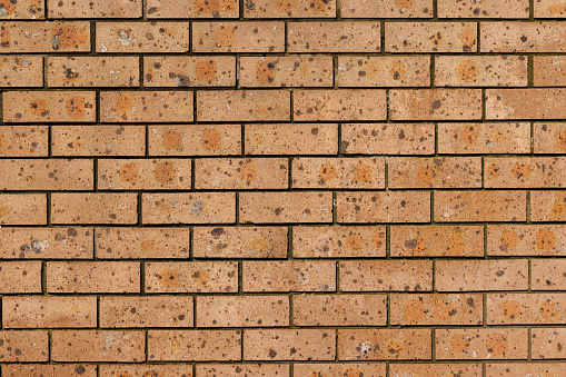 Section of an old brown brick wall.