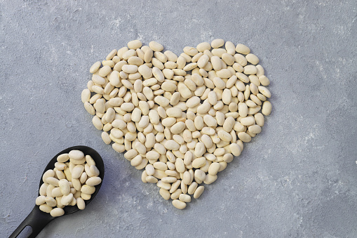 white kidney beans in a heart shaped a on white background.Top view.