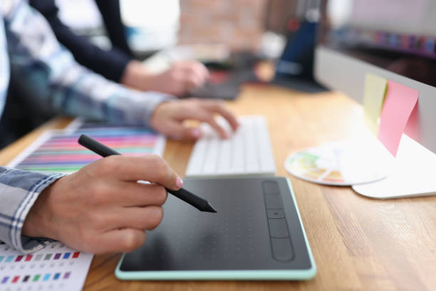 istock Woman designer writing on graphics tablet with stylus closeup 1408348463