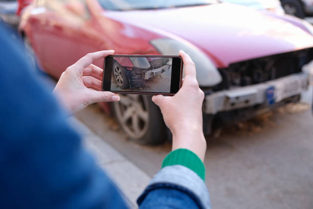 istock Insurance agent photographing broken car on mobile phone closeup 1408348500